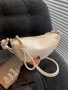 Minimalist beige crescent shoulder bag with a stylish knot strap detail and smooth zipper