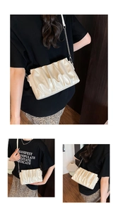 Detail view of cream pleated crossbody bag with chain strap shown on model's side