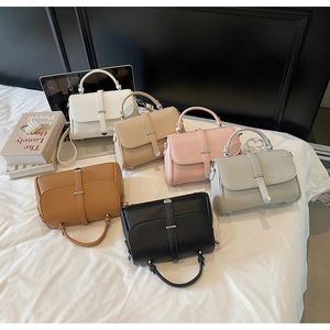 Detail shot of pebbled leather shoulder bags in six colors with metal buckle accents