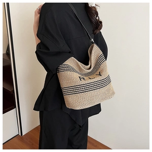 Straw shoulder bag with black stripes and RLY embroidery shown on a model