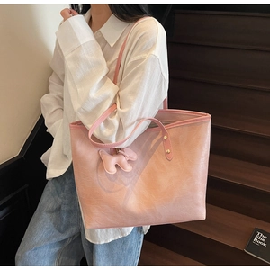 Pink croc-embossed tote bag featuring a cute dog charm on a scenic stone staircase