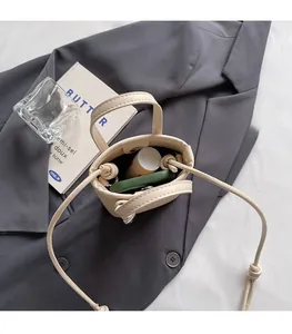 Detail view of cream mini bucket bag interior with metal magnetic closure and smooth faux leather