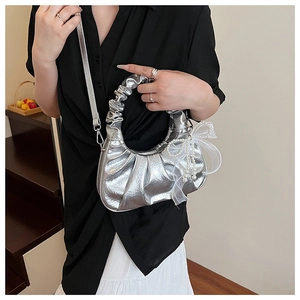 Détail du sac hobo métallisé argenté avec texture plissée et nœud en dentelle et perle