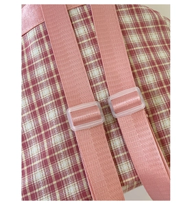 Détails des bretelles roses réglables et boucles givrées du sac à dos à carreaux