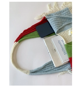 Detail showing high capacity of boho knit tote bag with tassel and floral texture