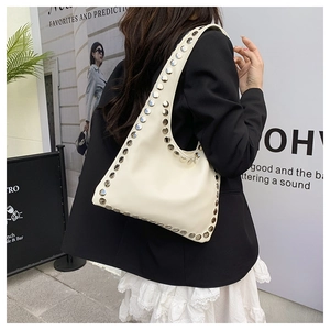 Détail du sac cabas crème avec des rivets argentés et une texture en similicuir lisse