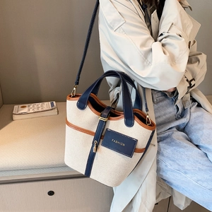 Elegante borsa a secchiello in tela con finiture in pelle a contrasto e tracolla regolabile