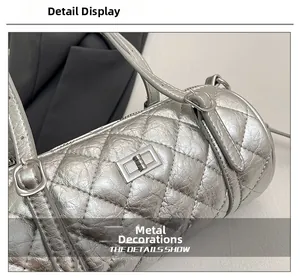 Détail du sac baril argenté matelassé avec fermoir rotatif et bandoulière réglable fine