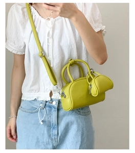 Détail du sac bowling jaune citron en cuir grainé avec ferrures argentées et pochette