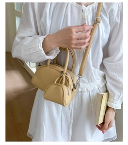 Détail du sac coquille en cuir jaune avec son mini porte-monnaie rond assorti