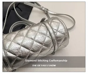 Détail des surpiqûres matelassées et du fini argenté métallisé du sac cylindrique