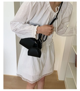 Détail du sac bowling noir en cuir grainé avec une petite pochette à monnaie assortie