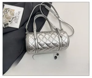 Détail du sac barillet argenté matelassé avec fermoir et comparaison de taille avec mobile