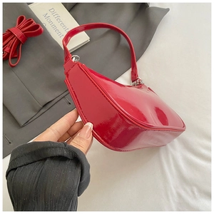 Detailed macro view of the glossy red patent leather bag with a stylish silver chain strap