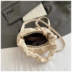 Detail view of the beige cloud tote bag's pleated PU leather texture and gold hardware