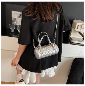 Vue arrière d'un mannequin portant le sac cylindre argenté matelassé en bandoulière