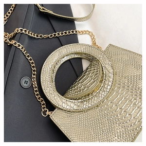 Detailed view of pale gold snakeskin texture handbag with large circular handle and chain