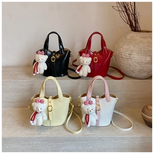 Detail view of colorful bucket bags with cute teddy bear charms on stone steps