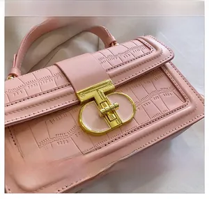 Close-up of pink faux crocodile skin texture and elegant golden T-bar twist lock detail