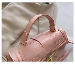 Macro detail of pink crocodile texture faux leather handbag with gold metal hardware