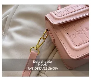 Macro detail of pink crocodile texture handbag with detachable golden metal swivel hook