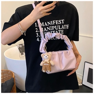 Detail of lavender pleated cloud bag with detachable strap and cute teddy bear charm