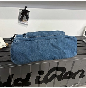 Detailed view of the bottom and side seams of a large capacity blue denim tote bag
