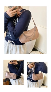Detail of pink patent leather bag with silver chain heart charms and shoulder strap