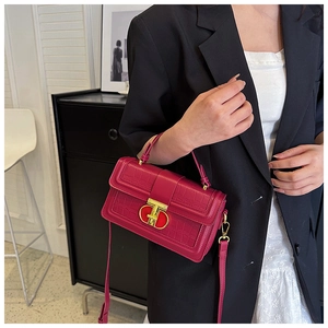 Fashionable rose red crossbody bag with crocodile texture and gold lock on model