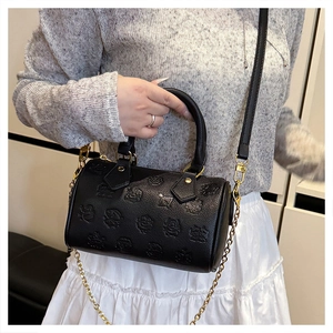 Detail der schwarzen Boston-Tasche aus Leder mit Cartoon-Prägung und goldener Kette