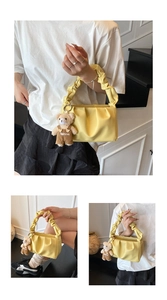 Detail of light yellow ruched cloud bag with cute bear charm and chain strap