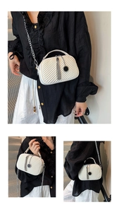 Détail du sac bandoulière blanc matelassé avec chaîne argentée et pendentif à pompon