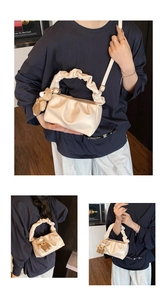 Detail of off-white pleated cloud bag with ruffle handle and cute brown bear charm