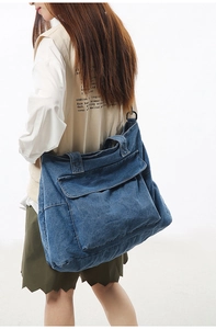 Detailed view of the large capacity blue denim tote bag with functional front flap pocket