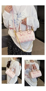 Detailansicht der rosa Boston Bag mit Sternzeichen-Prints und goldenem Kettenriemen