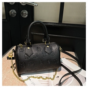 Detailansicht der schwarzen Boston-Tasche mit Bärenprägung und goldener Kette