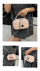 Vue détaillée du sac bandoulière matelassé rose avec chaîne argentée et pompon