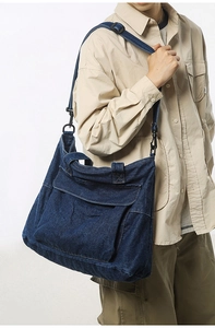 Detail of blue denim tote bag showing metal D-ring buckle and adjustable shoulder strap