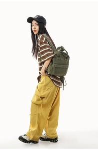 Detailed view of the durable army green canvas backpack with sturdy handles and front pocket