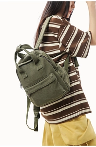 Side view of army green canvas backpack on model showing durable pockets and straps