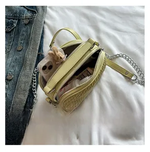Vue intérieure d'un sac bandoulière tissé jaune montrant l'espace de rangement