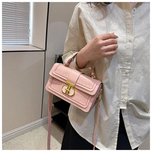 Pink faux leather box bag with grid embossing and gold clasp shown by model