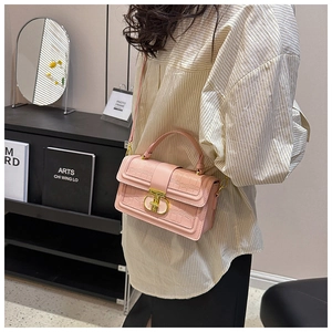 Detail of pink croc-embossed handbag showing the gold metal buckle and top handle