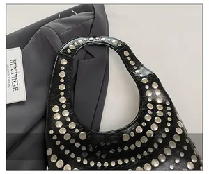 Detailansicht der schwarzen Lackleder-Handtasche mit Silbernieten und Hohlgriff