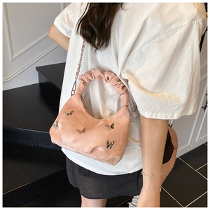 Sac Boston en satin rose avec papillons et anse plissée porté par un mannequin