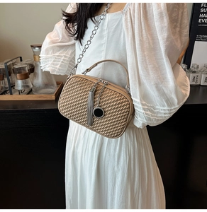 Détail du sac bandoulière beige en similicuir matelassé avec chaîne argentée et pompon