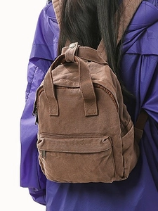 Women's brown canvas backpack with adjustable straps and front pocket for casual travel