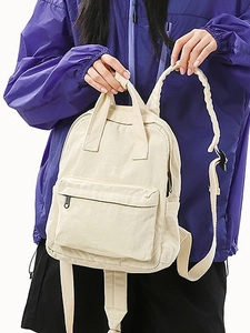 Women's minimalist off-white canvas backpack with dual top handles and front pocket