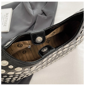 Details der Handtasche mit Nieten, Magnetverschluss und bedrucktem Innenfutter