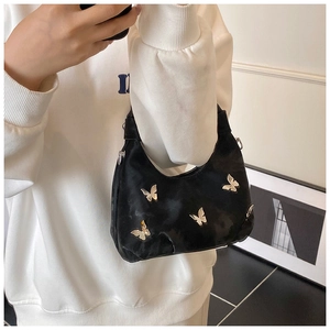 Détail d'un sac hobo en velours noir orné de quatre papillons en métal argenté